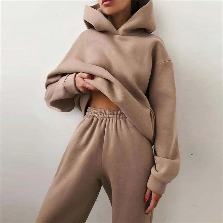 Close-up of the tan hoodie and elastic-waist pants worn by a model lifting the hem 2