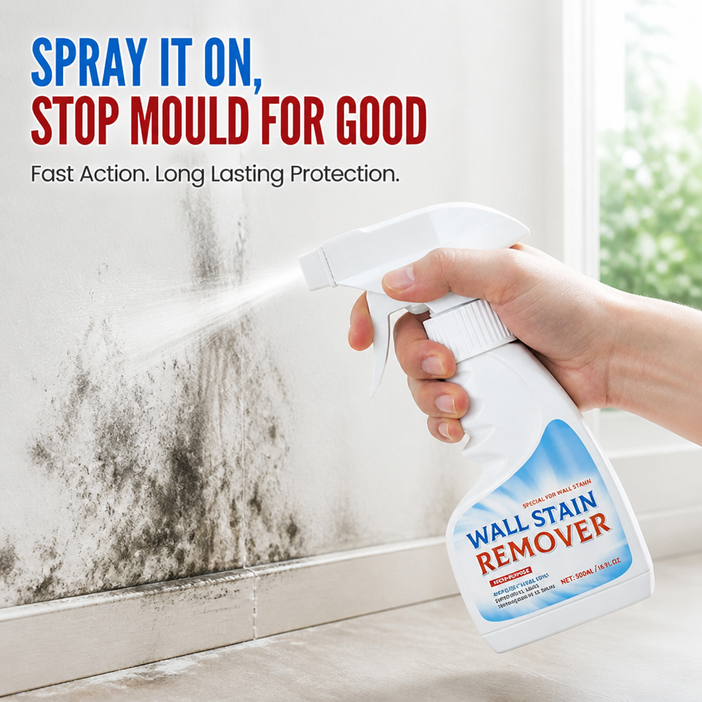 Hand holding the spray bottle and misting a mold-stained wall above a white baseboard, another view.