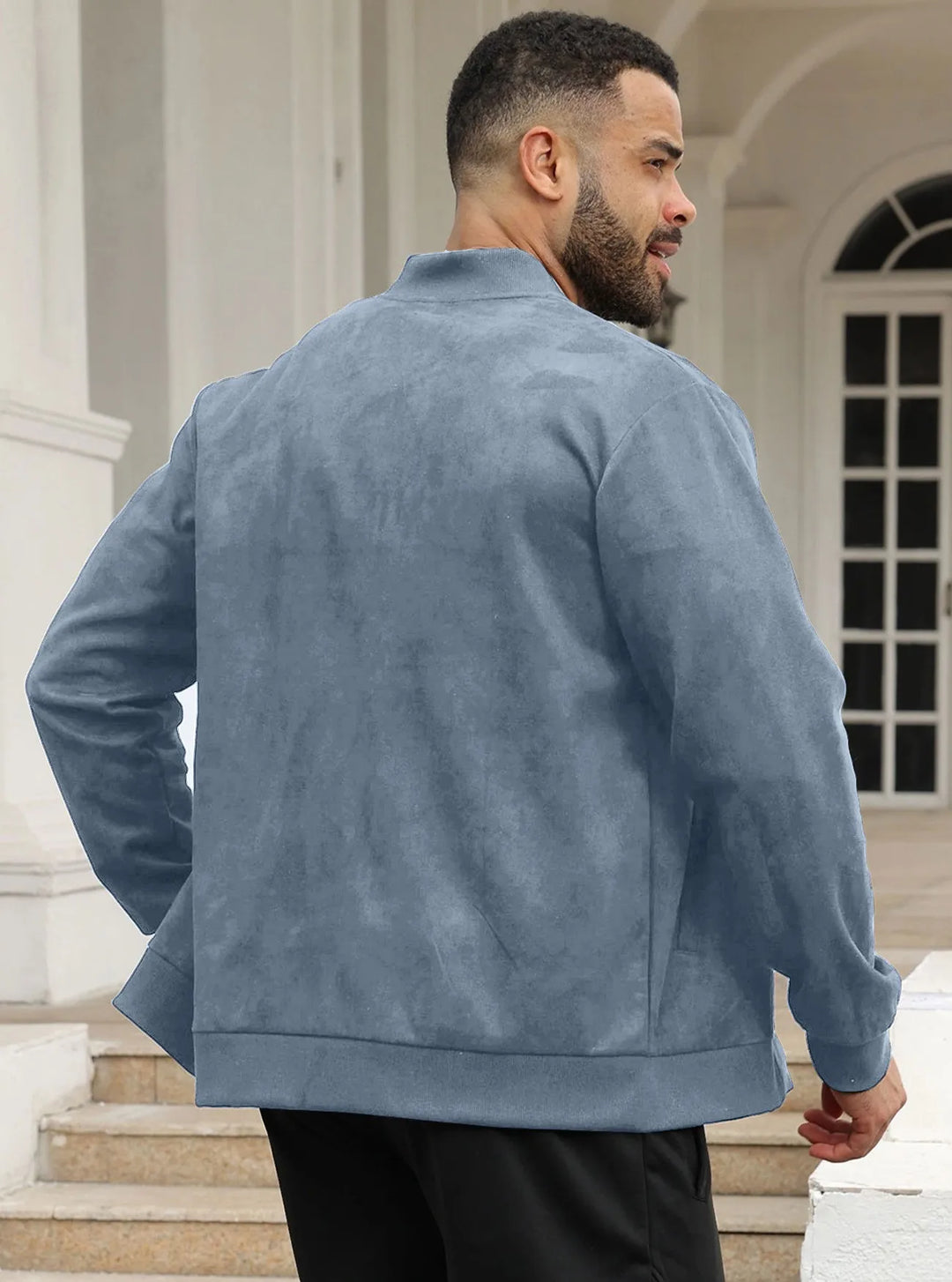Man in slate blue suede-look bomber jacket seen from behind, standing on steps by white columns 31