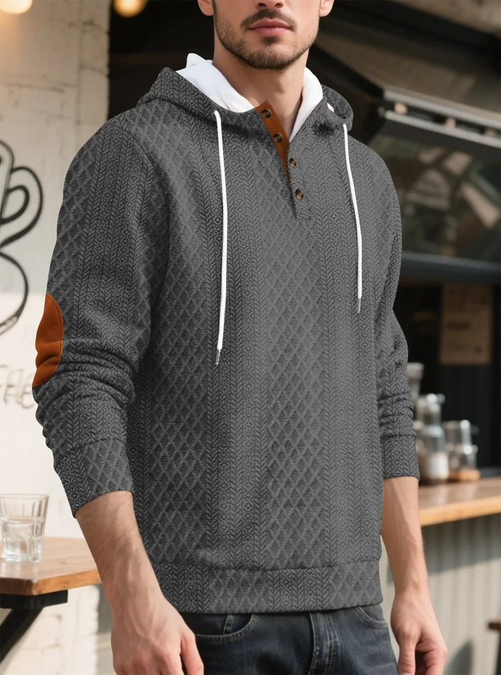 Man standing beside a cafe counter in the gray textured hoodie, angled front view 32