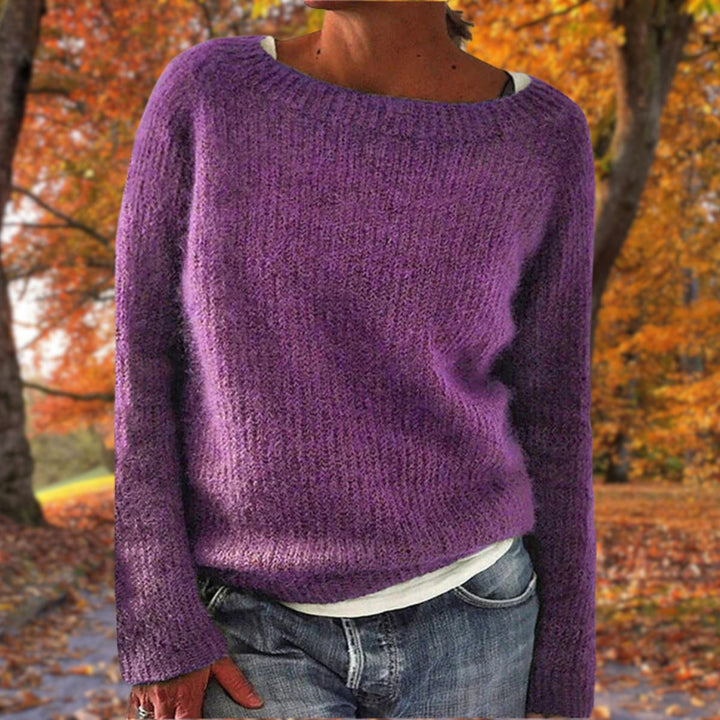 Purple knit sweater with a round neckline, worn over a white tee and jeans in an autumn setting 7