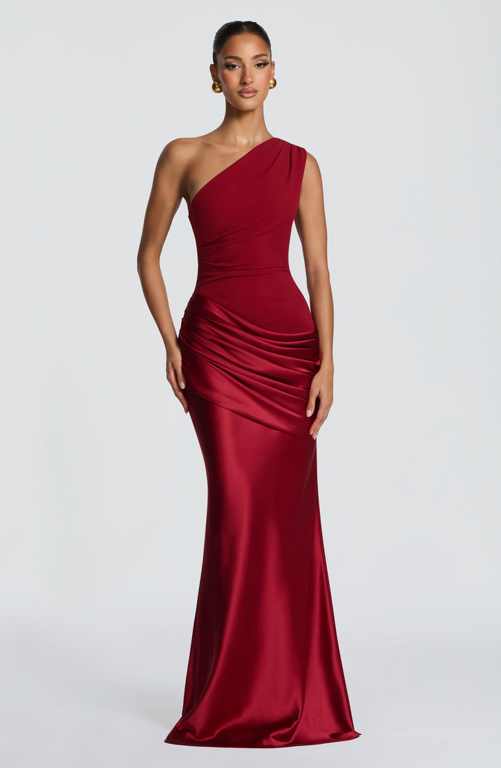 Deep red one-shoulder gown on a model, front view with glossy satin skirt and ruched hip drape. 15