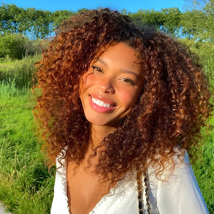 Another view of curly hair in a warm copper-auburn tone with a white ruffled blouse.