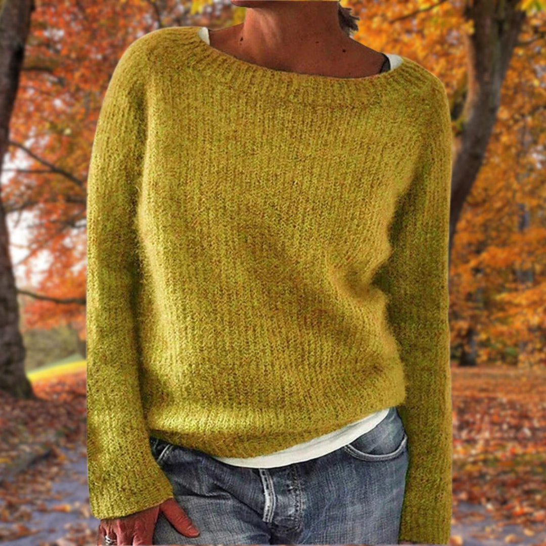 Mustard yellow knit sweater with a round neck, worn over a white tee and jeans among autumn trees 1