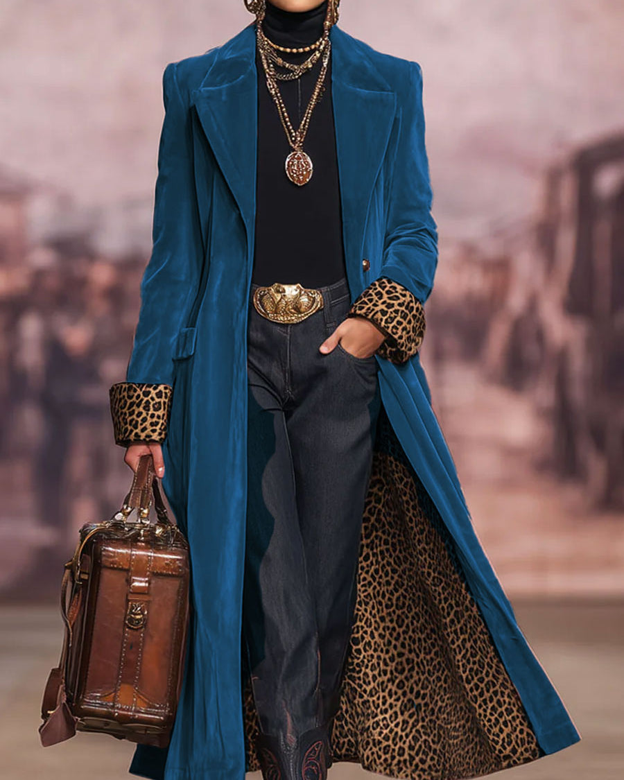 Same coat in a deep teal-blue velvet-effect, worn open to show the leopard-print lining and cuffs, with jeans and a brown leather bag. 6