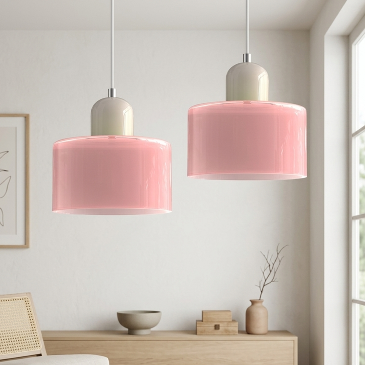 Two pink glass drum pendants with greige dome caps hang on white cords in a bright living room. 36