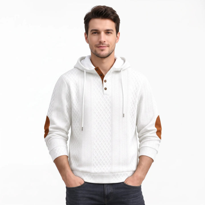Studio shot of a man in the white textured hoodie with hands in pockets 38