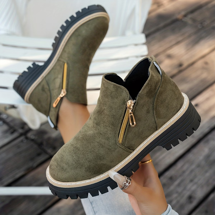 Olive green suede-look ankle boots with gold side zippers and thick treaded soles.