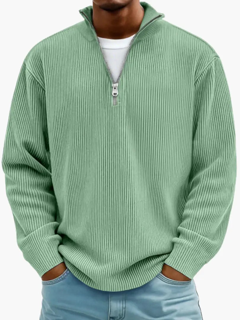 Man wearing the ribbed quarter-zip sweater in soft mint green over a white tee, hands in jeans pockets.