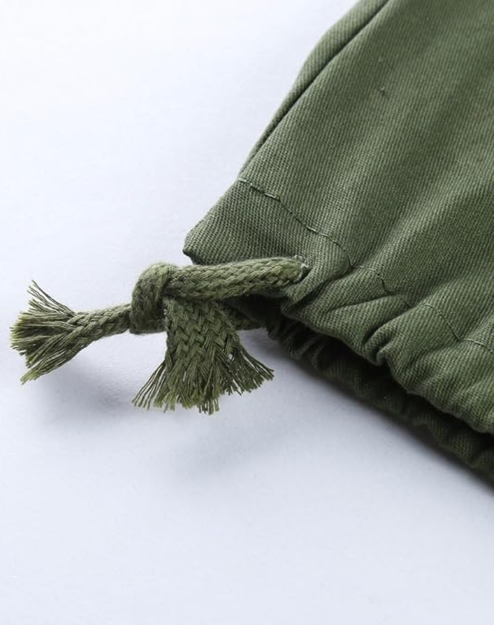 Close-up of a knotted drawstring cord with frayed ends at the gathered hem of olive green cargo pants. 12