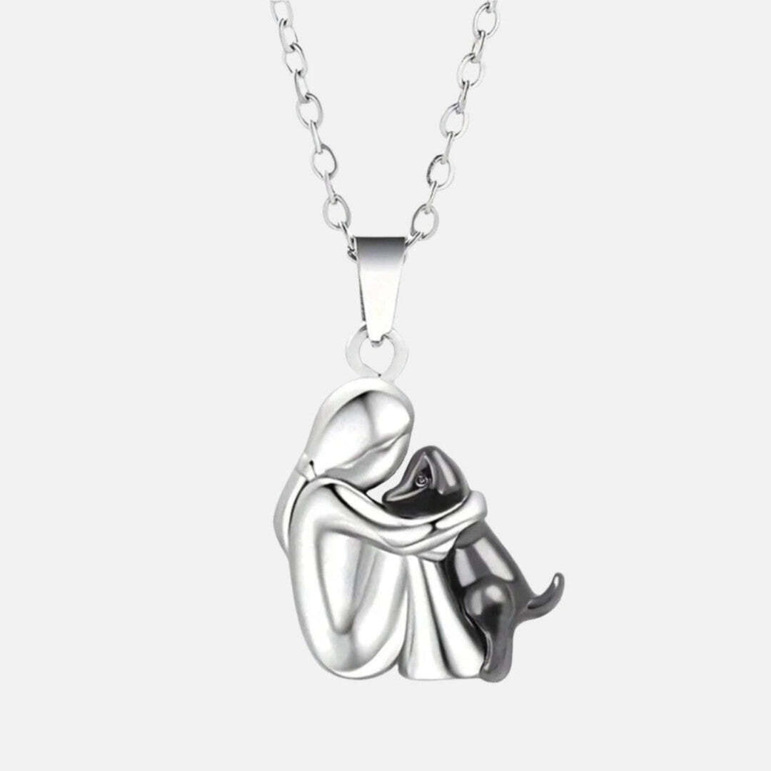 Pendant variation with a silver figure hugging a dark gunmetal dog on a silver chain.