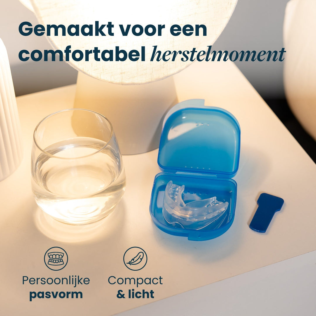Clear recovery mouthpiece resting in an open blue storage case beside a glass of water.