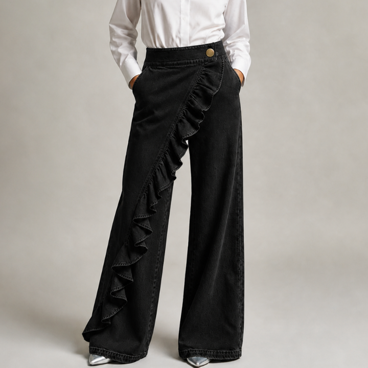 Black wide-leg denim pants with a diagonal ruffle and gold button, front view.
