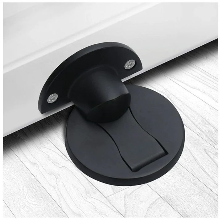 Matte black version of the door stopper, with the round floor base and screwed door plate set against pale wood flooring. 2