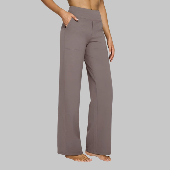 Women's taupe-brown straight-leg pants with a wide waistband, one hand in the side pocket, three-quarter side view.