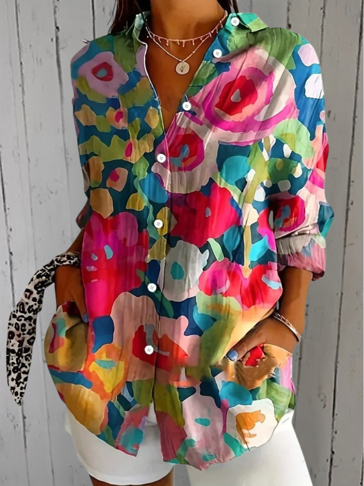 Anica blouse detail with a bold abstract print of oversized red, pink, teal and yellow flower shapes.