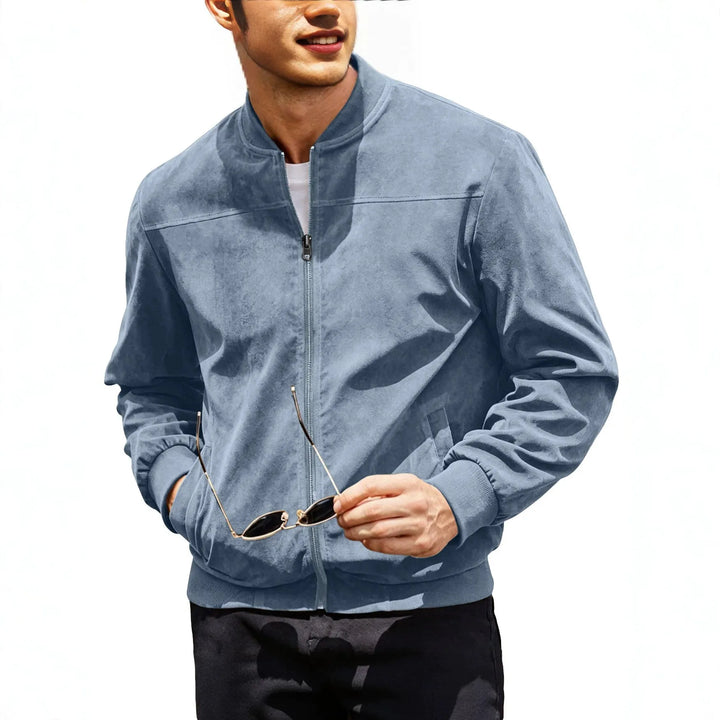 Torso of a model in a light blue zip-up jacket holding sunglasses, one hand in pocket 3