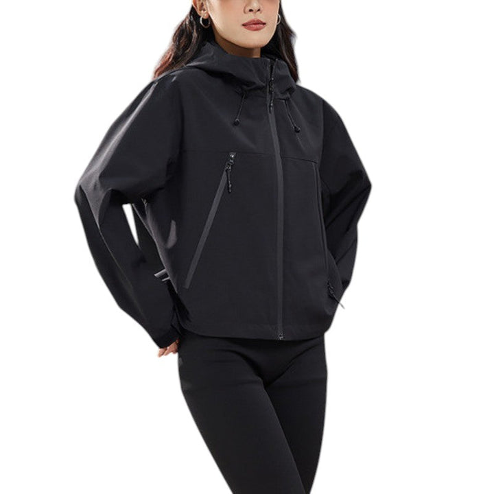 Close front view of the black jacket without a cap, hood up, hands in pockets and drawcords hanging at the chest. 17