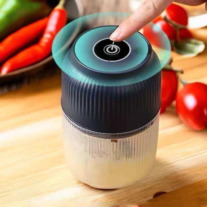 USB Rechargeable Mini Food Chopper detail with a fingertip pressing the power button on the blue lid.