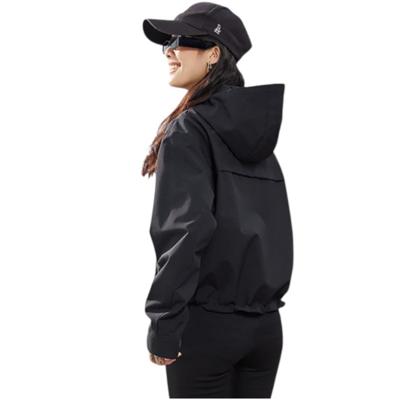 Side and back view of the black jacket showing the hood and gathered hem, model smiling in profile. 18