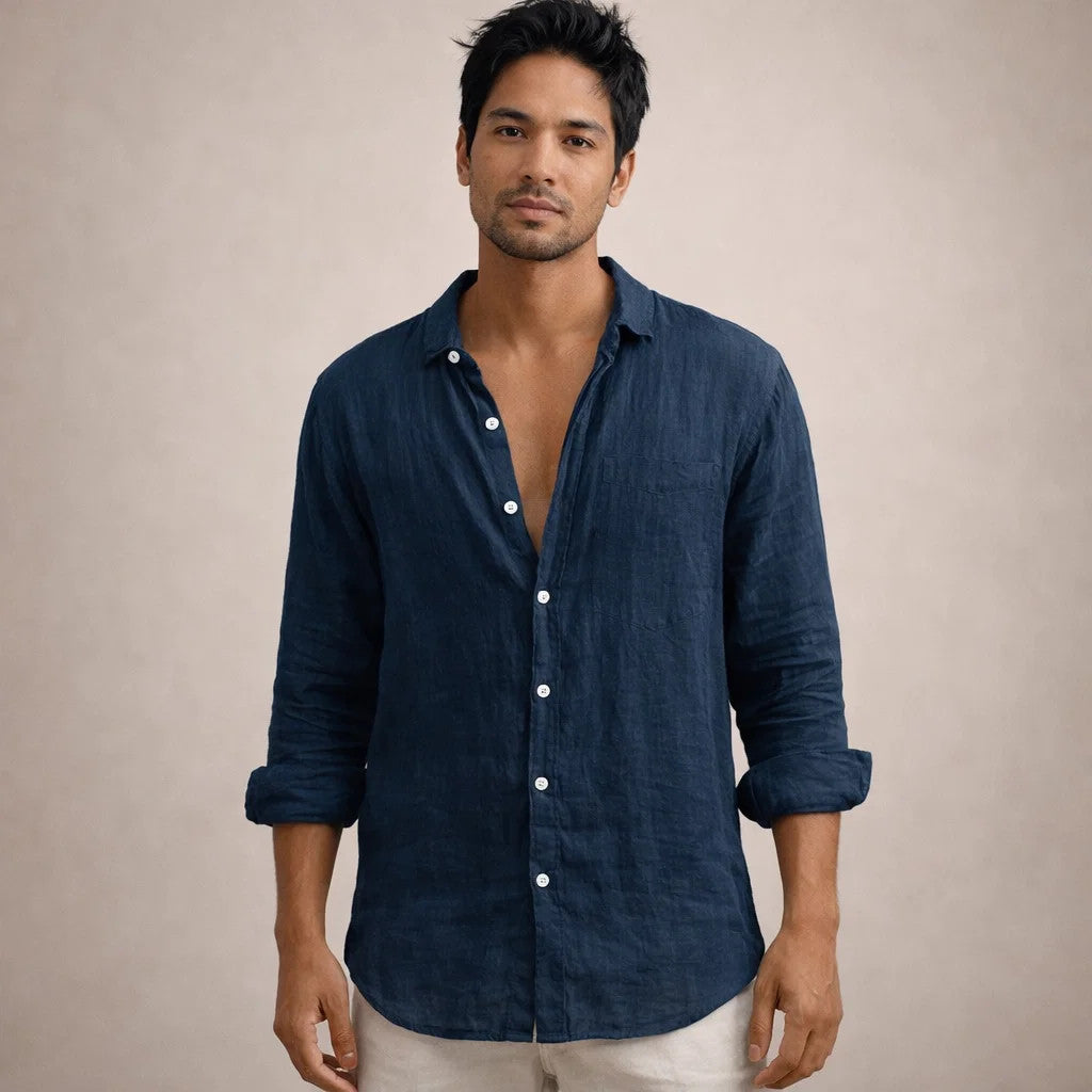 Model facing the camera in the navy linen shirt with a chest pocket, white buttons and rolled sleeves.