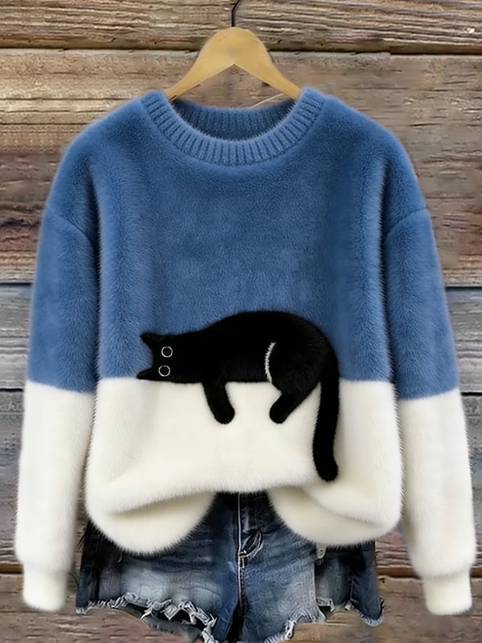 Medium blue and white fuzzy colorblock sweater with a black cat design on the front, shown on a hanger against wood. 9
