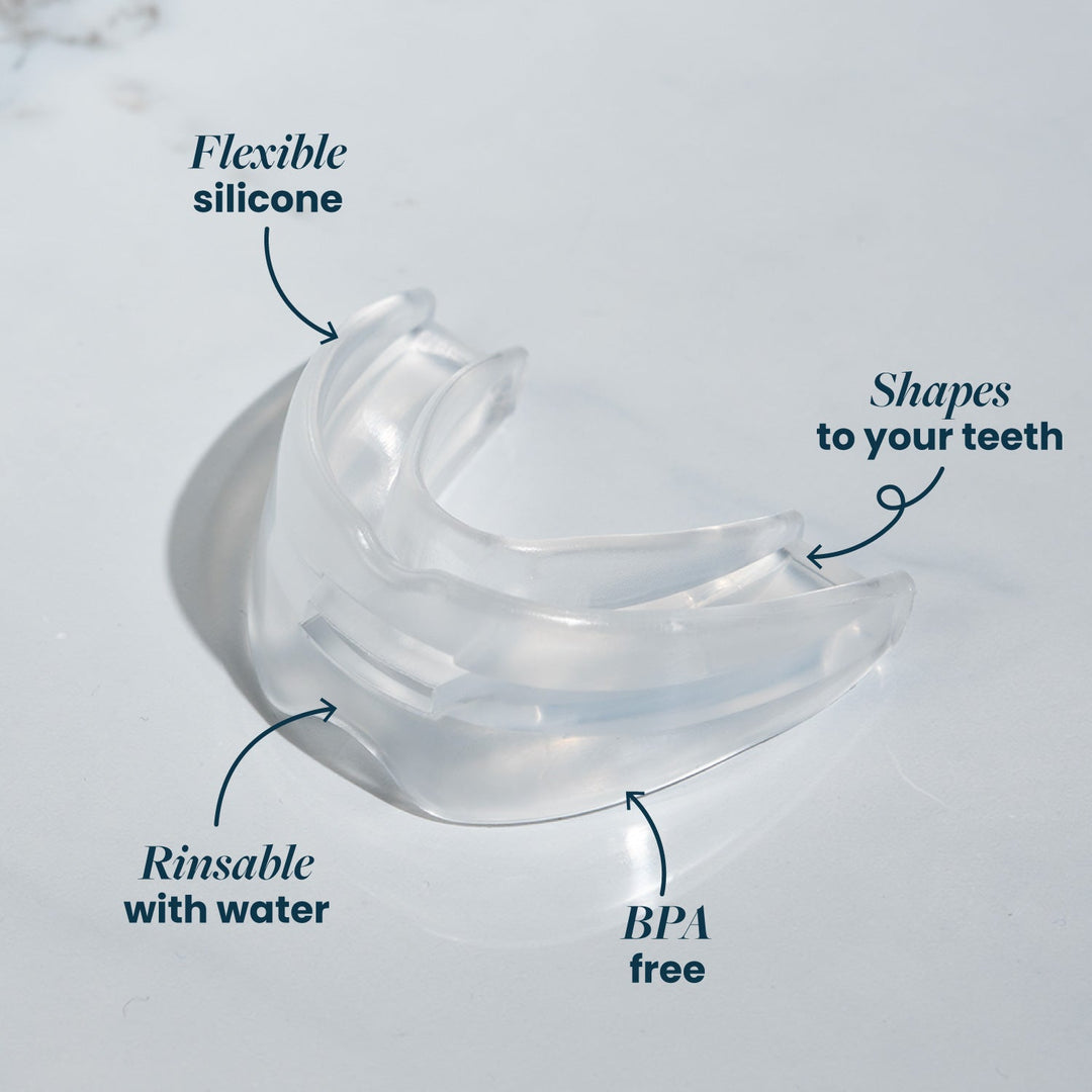 Close-up of the clear, flexible silicone mouthpiece on a pale surface, with arrows pointing out its features. 23