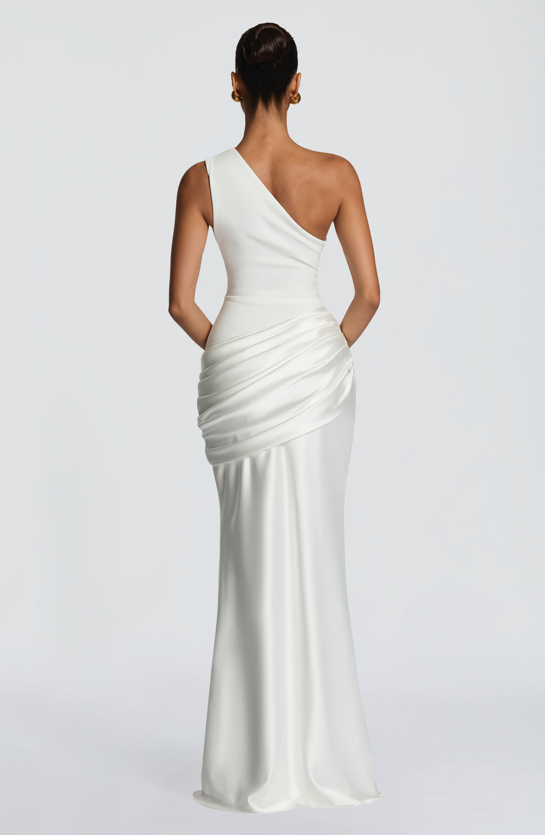 Back view of the white one-shoulder dress, showing the asymmetric neckline, open back and gathered satin drape at the hip. 23