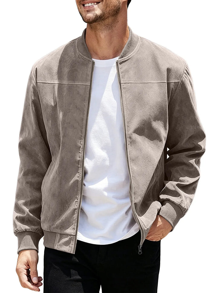 Man wearing the taupe zip-up bomber open over a white tee, one hand in pocket 43
