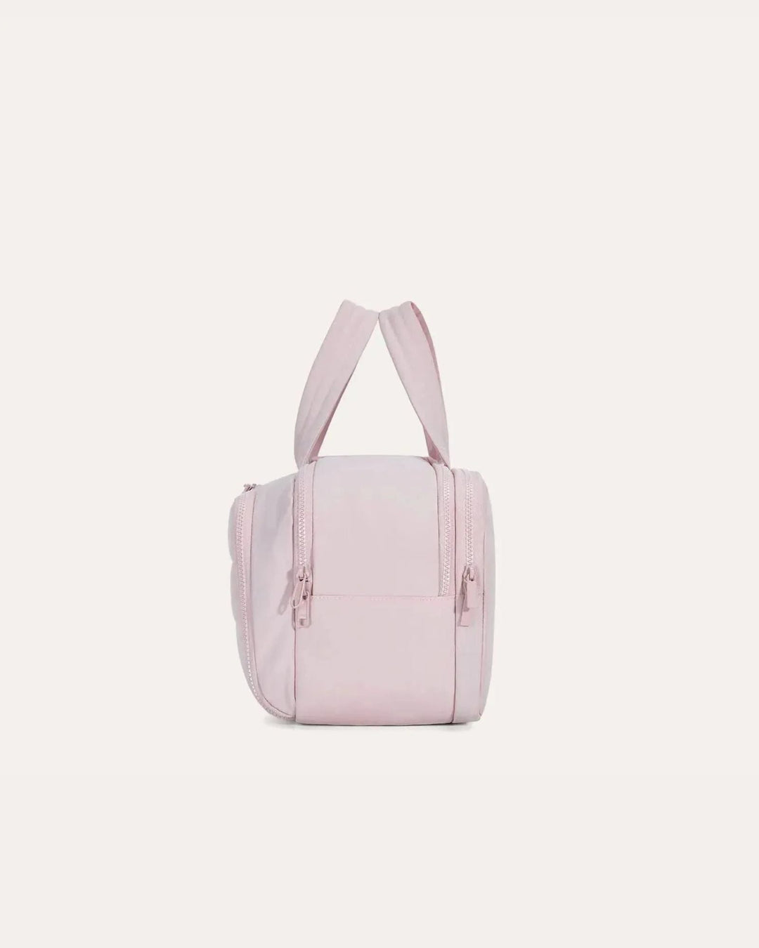 Side view of the pink bag showing its upright handles, two side zippers and the plain side panel.