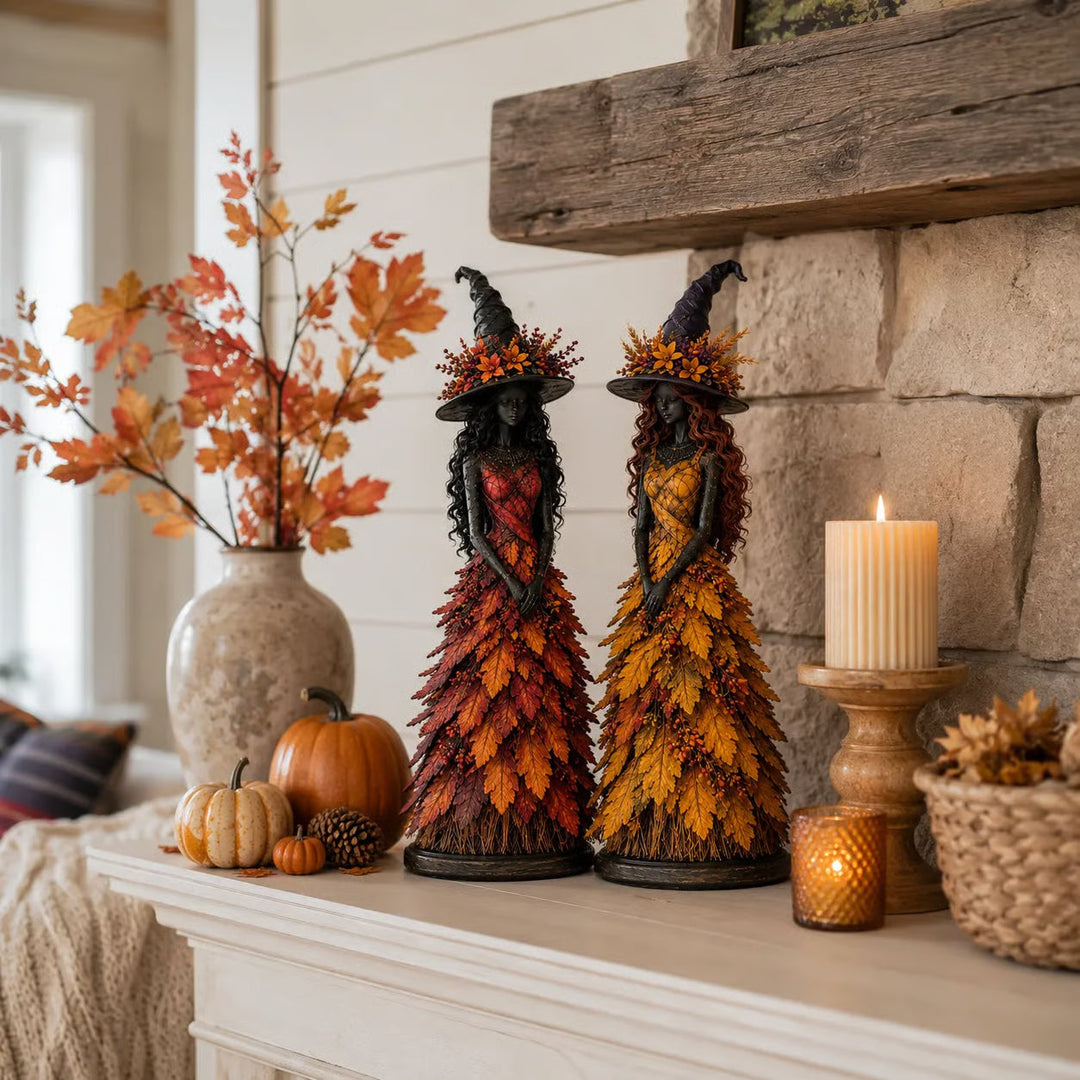 Red-orange and golden-yellow witch figurines on a white mantel by a stone fireplace with candles, small pumpkins and autumn branches. 6