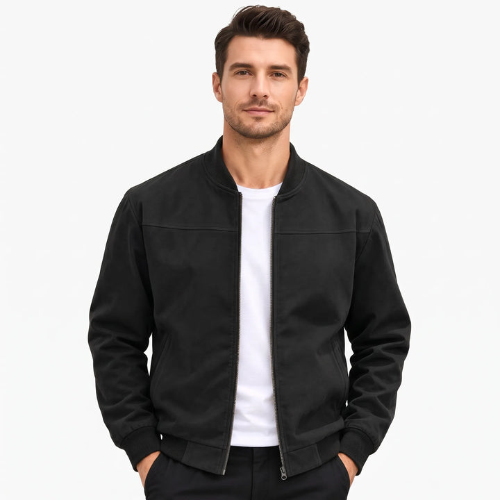 Studio shot of a man in the black bomber jacket, hands in dark pants pockets 49