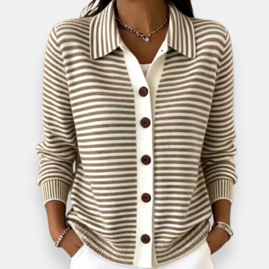 Woman wearing the collared cardigan in taupe and white stripes with brown buttons, white placket, ribbed cuffs, hands in pockets. 1