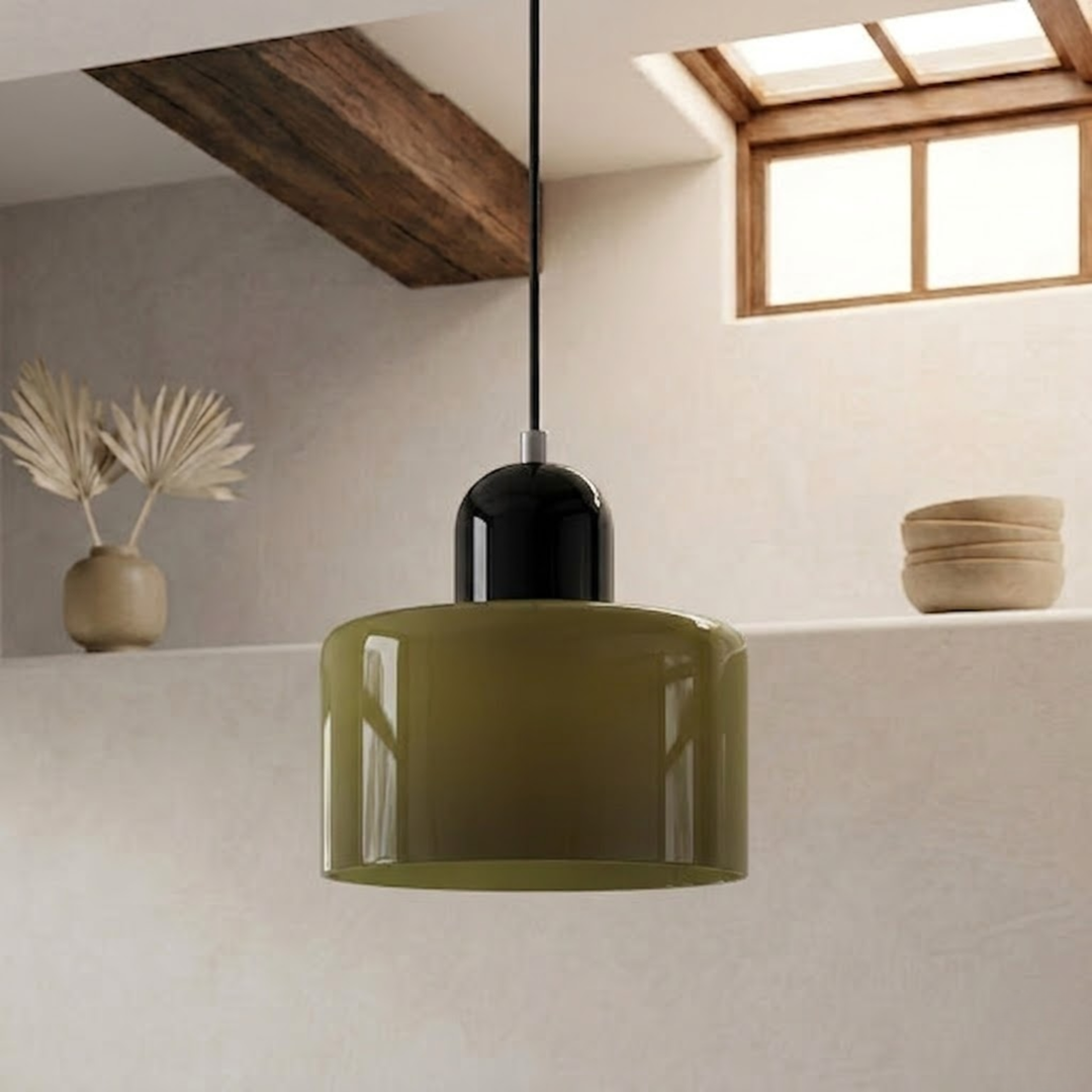 Olive green glossy drum shade capped in black, hanging on a black cord in a minimalist room with a wooden beam. 10