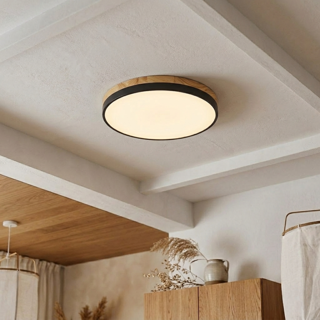 Black-banded disc ceiling light with a thick wood-grain upper ring glowing warm white on a beamed ceiling. 12