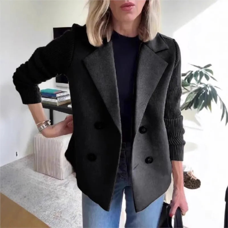 Black double-breasted jacket with ribbed sleeves, styled with jeans in a bright living room setting 4