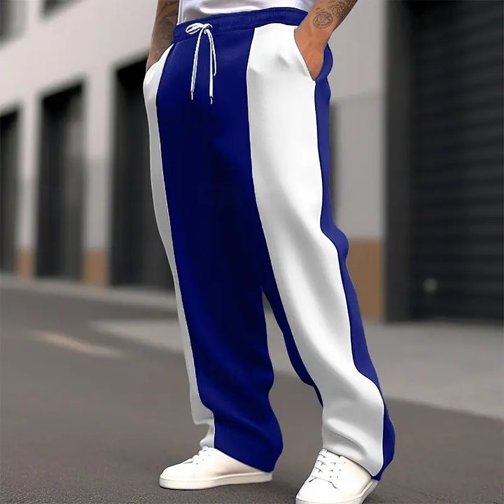 Cropped street shot of navy and white color-block sweatpants with drawstring waist and white sneakers 4