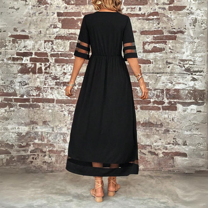 Back view of the black maxi dress showing the gathered waistline, sheer-striped sleeves and sheer band at the hem. 3