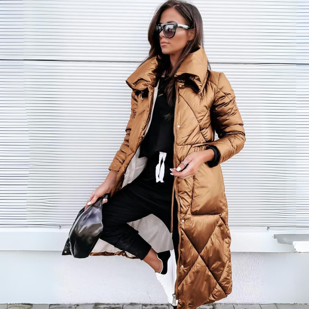 Long quilted puffer coat in glossy bronze-brown, worn open over a black outfit.