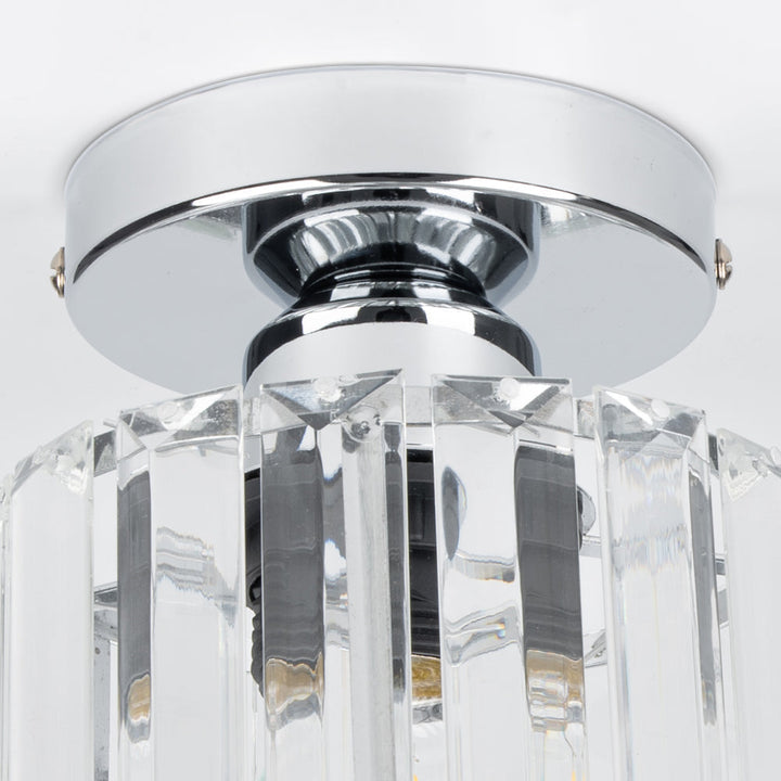 Close-up detail of the ceiling light with a round canopy and clear crystal prism panels.
