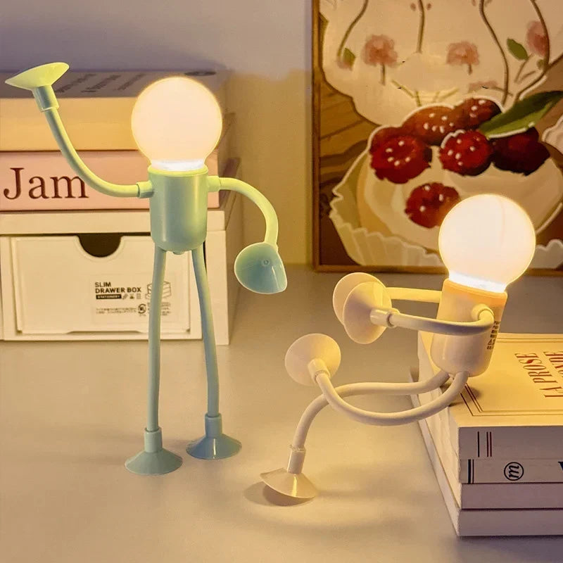 Green and cream posable figure lights glowing on a shelf, one standing with arm raised, one crouching 4