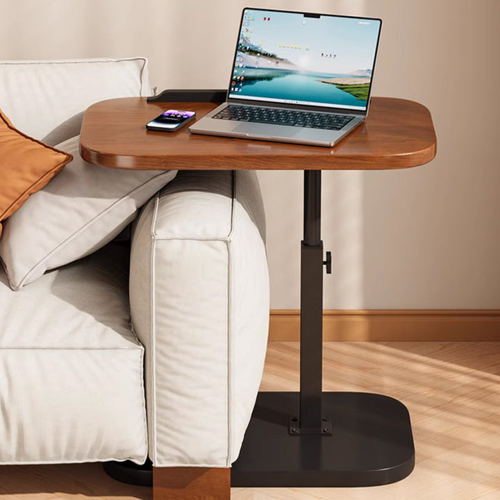 Black rolling laptop desk side view with base slid under a sofa arm