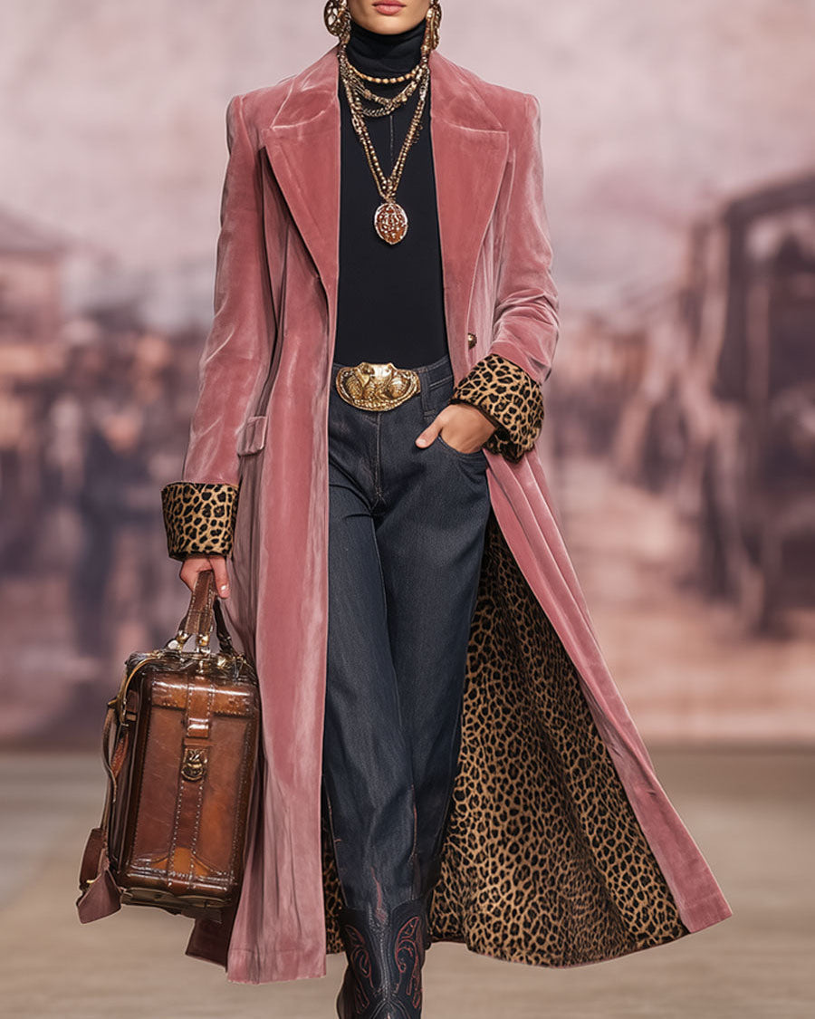 Model on a runway-style backdrop wearing the pink coat open, hand in pocket, with leopard-print cuffs and lining visible and a leather bag. 3