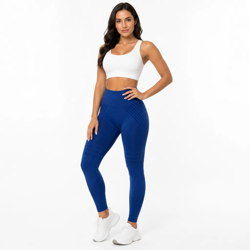 Front view of royal blue high-waisted leggings with ribbed waistband, worn with a white sports bra and white sneakers. 26