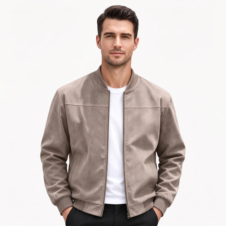Studio shot of a man in the taupe bomber jacket, hands in black pants pockets 50