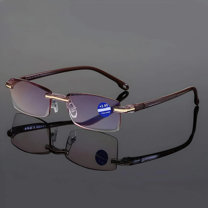 Rimless reading glasses with brown temples and gold-tone hinge accents on a glossy gray surface.