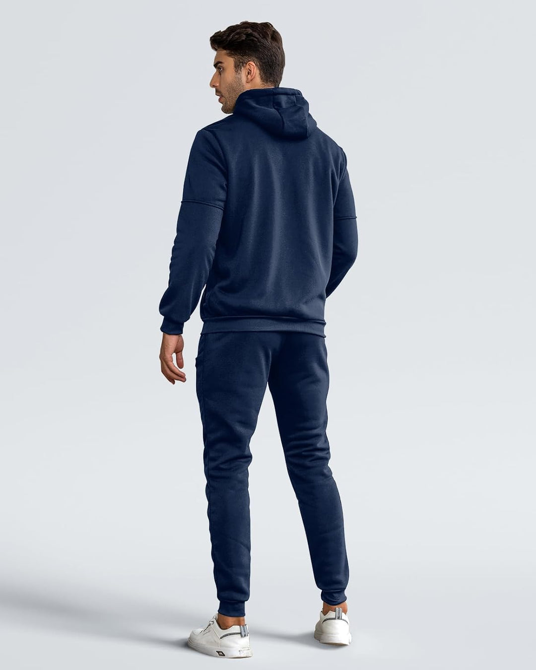 Back view of model wearing the navy hoodie and joggers, showing the hood and ribbed cuffs 4