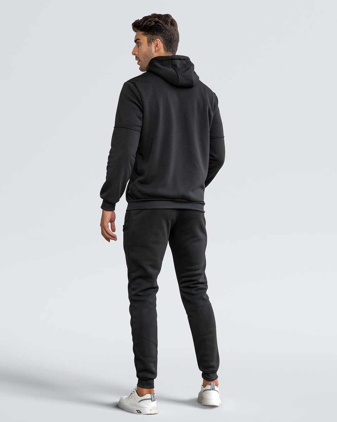 Back view of a man wearing the black hoodie and matching jogger pants with ribbed cuffs 9