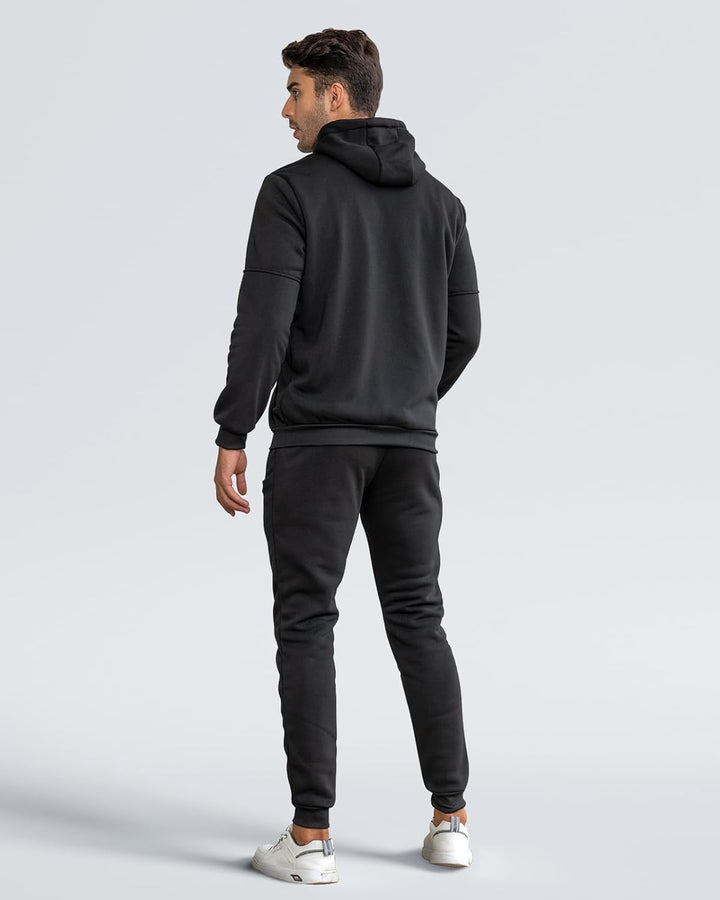Back view of a model wearing the black hooded sweatshirt and jogger pants set 12