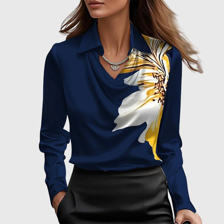 Model wearing the navy blue satin blouse with a large white and yellow flower print on one side, cowl neck and pointed collar.